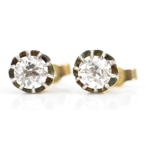 257 - A pair of white and yellow gold diamond earrings, each having an old cut stone in a claw setting, ap... 