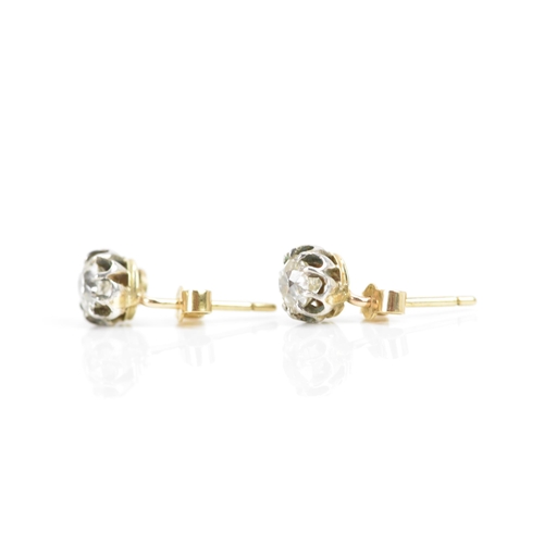 257 - A pair of white and yellow gold diamond earrings, each having an old cut stone in a claw setting, ap... 