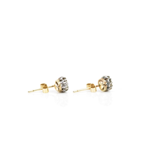 257 - A pair of white and yellow gold diamond earrings, each having an old cut stone in a claw setting, ap... 