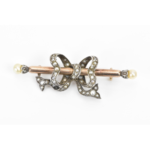 263 - A Victorian yellow and white metal brooch, fashioned as a ribbon on a bar, inset with several seed p... 