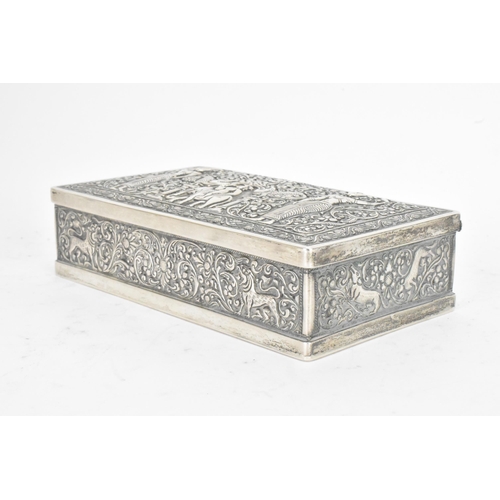 62 - An early/mid 20th century Indian silver cigarette box, the lid and side panels embossed with scenes ... 