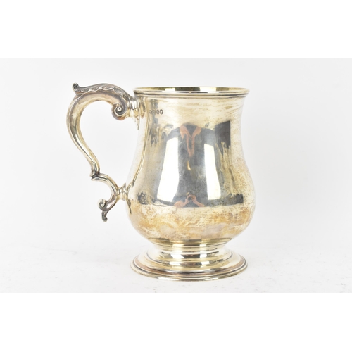 97 - A Victorian silver tankard hallmarked London 1877, makers marks rubbed, the body of baluster form an... 