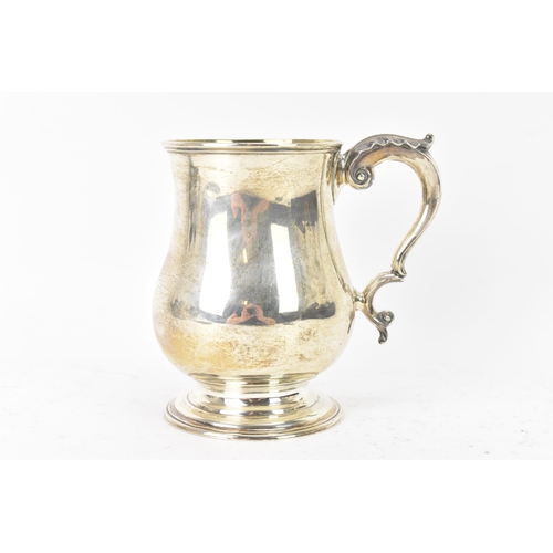 97 - A Victorian silver tankard hallmarked London 1877, makers marks rubbed, the body of baluster form an... 