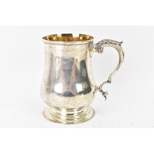 98 - A Victorian silver tankard hallmarked London 1861, makers marks rubbed, the body of baluster form an... 