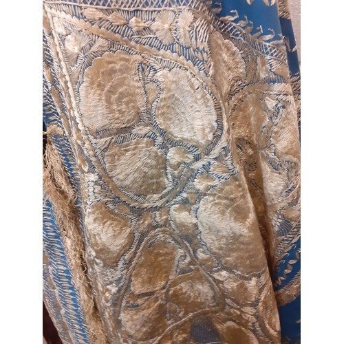 39 - A mid 19th Century Anglo-Indian embroidered cape having blue ground with intricate cream silk embroi... 