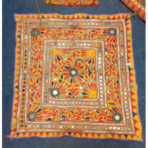 128 - A group of traditional hand embroidered Indian decorative items to include Banjari textile panels wi... 