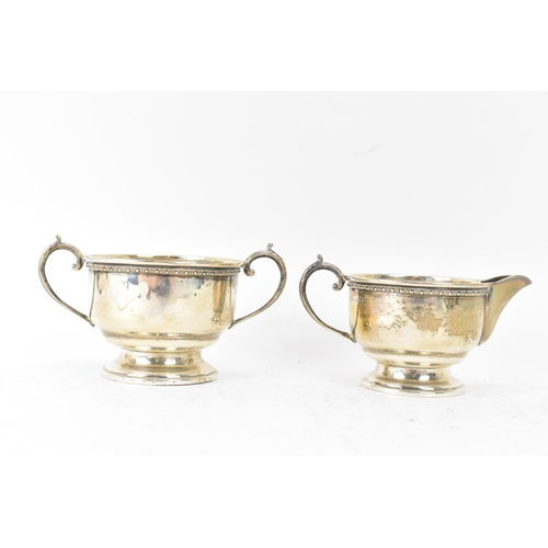 290 - A George V silver three piece tea service, hallmarked Birmingham 1932, consisting of a teapot, milk ... 