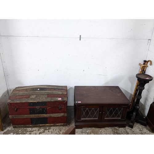 211 - A mixed lot of furniture to include a partially leather clad wooden domed top trunk, an Old Charm TV... 