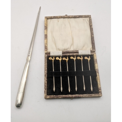 128 - Silver to include six cocktail sticks in a fitted case, hallmarked London 1928, along with a meat sk... 