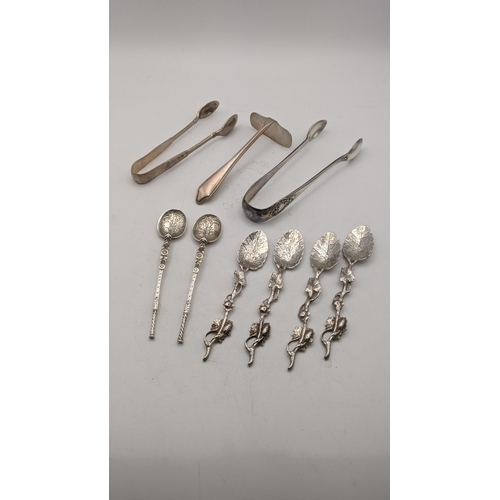 133 - Two pairs of sugar tongs, a silver pusher, a pair of decorative coffee spoons and four white metal s... 