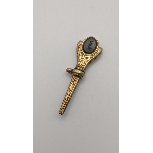 167 - A gold 19th century engraved pocket watch key with the terminal having a swivel for set with two sem... 