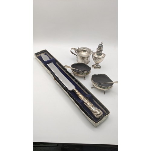 180 - Silver to include a pepper pot, a pair of salts and a mustard pot, and a silver handled bread knife,... 