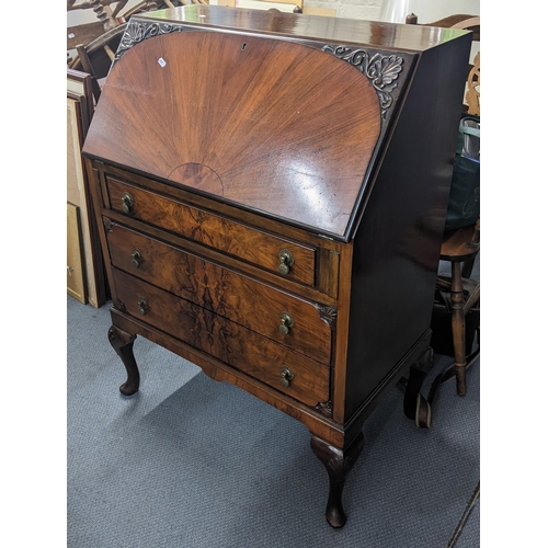 258 - An early /mid 20th century Queen Anne style walnut bureau having a fall flap above three drawers, 10... 