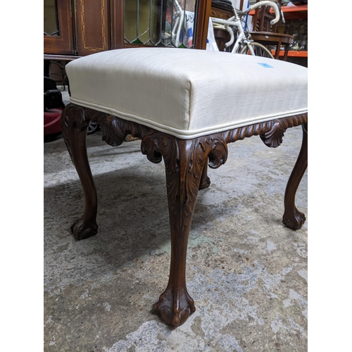 261 - An early 20th century carved walnut upholstered stool, white fabric seat on carved cabriole legs and... 