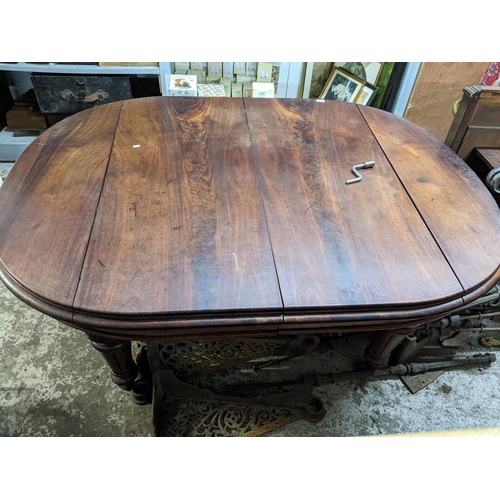 277 - A late Victorian mahogany wind-out dining table on turned, carved and fluted legs on ceramic castors... 