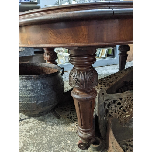 277 - A late Victorian mahogany wind-out dining table on turned, carved and fluted legs on ceramic castors... 