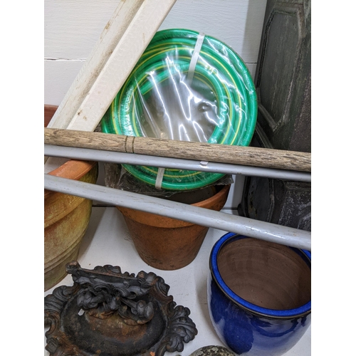 331 - Garden related items to include pots, garden ornaments, a boot scraper, an unused hose, wooden stake... 