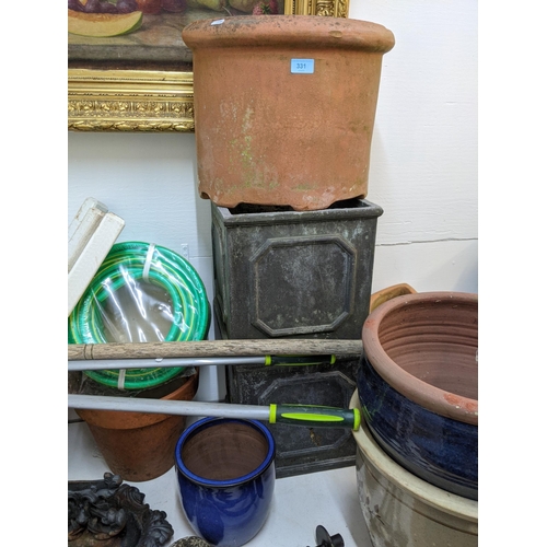 331 - Garden related items to include pots, garden ornaments, a boot scraper, an unused hose, wooden stake... 