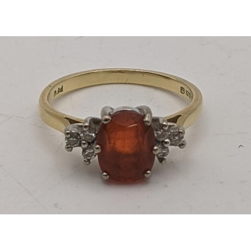 70 - An 18ct gold ring set with diamonds to the shoulders and a central amber coloured stone 2.9g
Locatio... 