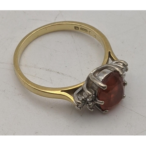 70 - An 18ct gold ring set with diamonds to the shoulders and a central amber coloured stone 2.9g
Locatio... 