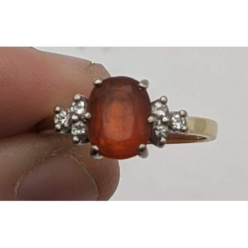 70 - An 18ct gold ring set with diamonds to the shoulders and a central amber coloured stone 2.9g
Locatio... 