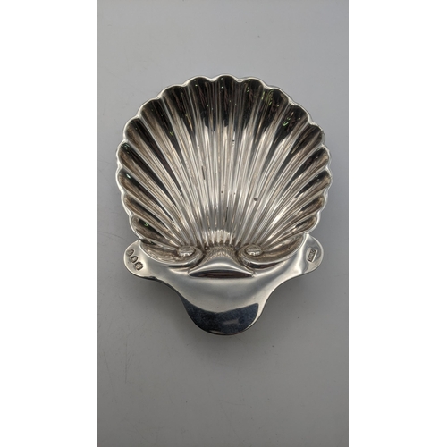 78 - Two silver items to include a shell shaped butter dish along with a twin handled dish with pierced b... 