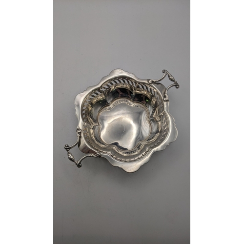 78 - Two silver items to include a shell shaped butter dish along with a twin handled dish with pierced b... 