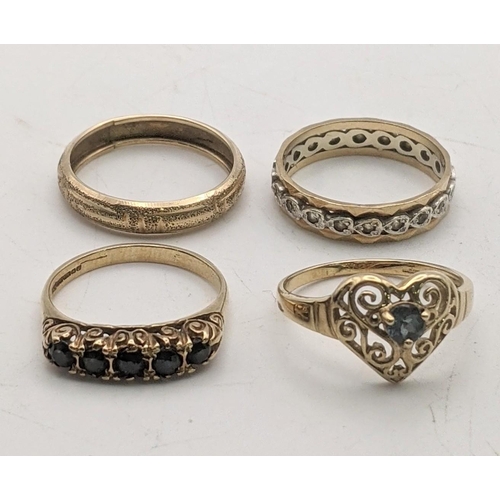 99 - Four 9ct gold ladies rings to include an eternity band, a decorative pierced love heart ring set wit... 