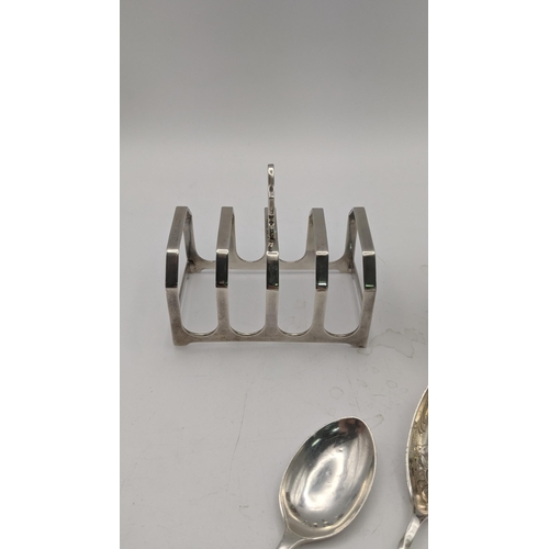 156 - Silver to include a pair of egg cups, a toast rack hallmarked Birmingham 1932, together with four sp... 