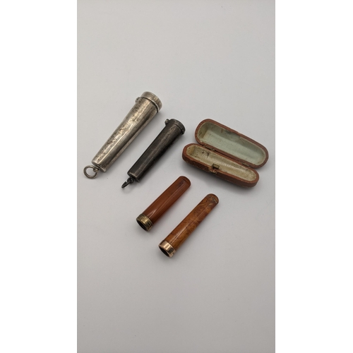 201A - Smoking related items to include two amber cheroots, one with an 18ct gold band and the other a ct g... 