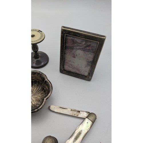 206A - Mixed silver items to include a pair of embossed pin dishes, a silver picture frame, mother of pearl... 