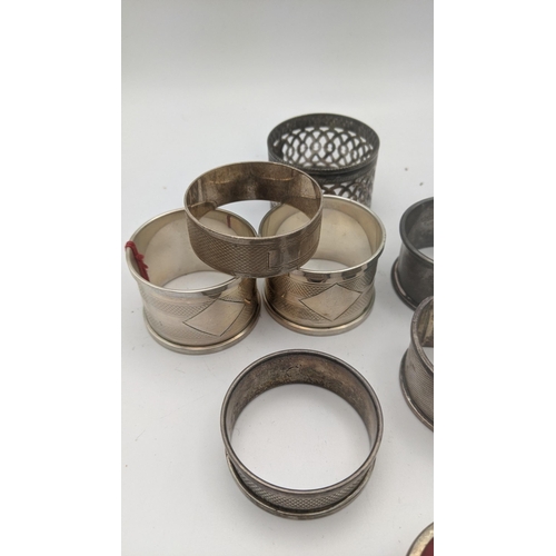 223 - Silver to include an assortment of napkin rings to include a pair of engine turned napkin rings, hal... 