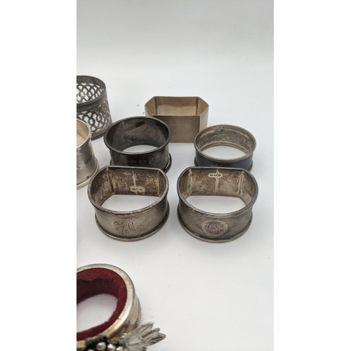 223 - Silver to include an assortment of napkin rings to include a pair of engine turned napkin rings, hal... 