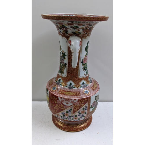 310 - A Japanese Kutani Meiji period vase having a flared rim with elephant head handles, decorated with f... 