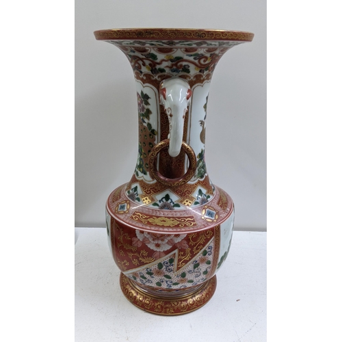 310 - A Japanese Kutani Meiji period vase having a flared rim with elephant head handles, decorated with f... 