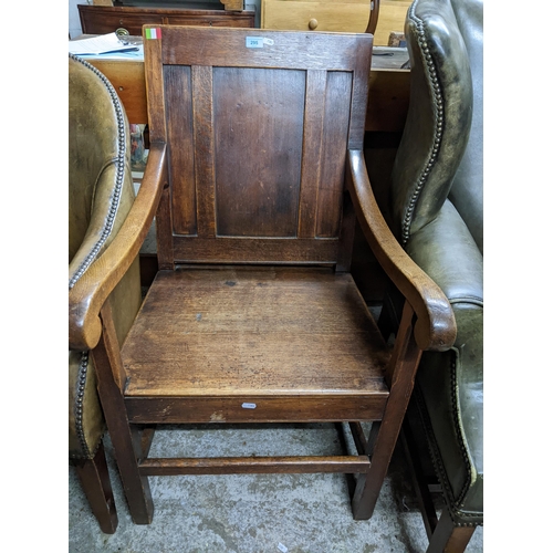 295 - A 20th century reproduction oak open armchair, panelled back, scrolled end arms on square supports, ... 