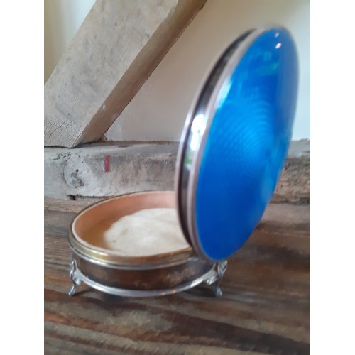 38 - An early 1900's silver and blue enamelled circular dressing table trinket box with hinged lid on 3 c... 