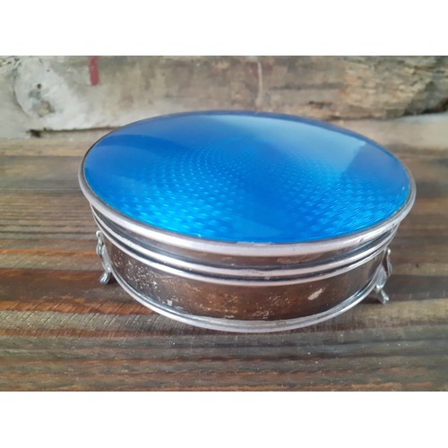 38 - An early 1900's silver and blue enamelled circular dressing table trinket box with hinged lid on 3 c... 