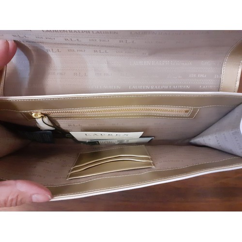 21 - Ralph Lauren-An unused cream clutch with cut-out design to the fold over flap, initials RLL in gold ... 