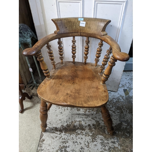 247 - A late 19th century spindle back Captain's chair with solid seat on turned legs united by double H-s... 