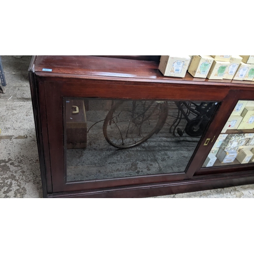 305 - A late Victorian mahogany bookcase, twin glazed sliding doors with inset brass handles, internal adj... 