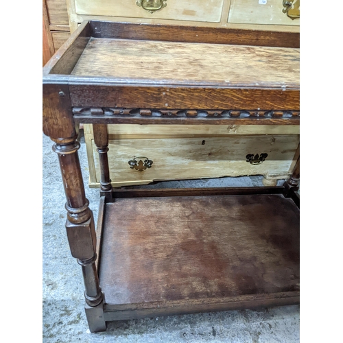 275 - A 20th century oak carved two tier tea trolley, galleried top and undertier, turned columns and bloc... 