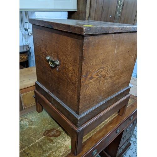 276 - A 19th century oak square form chest on later stand, hinged top, twin brass carrying handles, the st... 