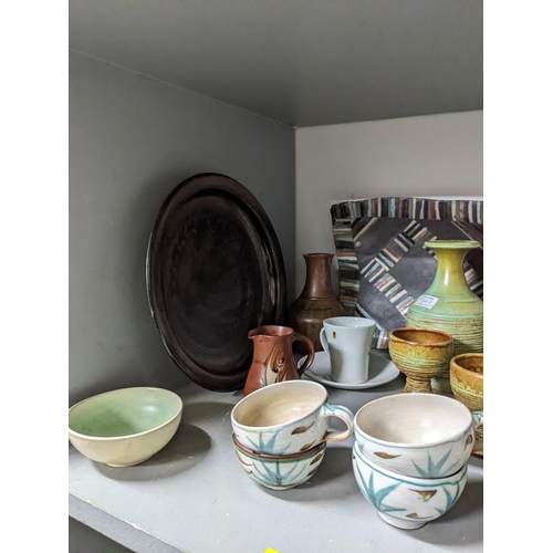 293 - A mixed lot of studio pottery to include an Edward Hughes cup and saucer A/F, St Ives Leach celadon ... 