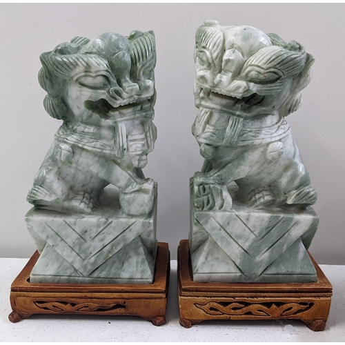 137 - A pair of Chinese jadeite models of foo dogs, each on pierced treen stands, 24.5cm h x 12cm w
Locati... 