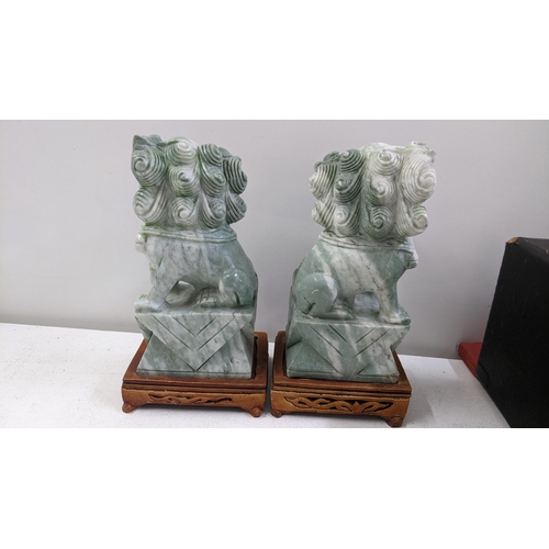 137 - A pair of Chinese jadeite models of foo dogs, each on pierced treen stands, 24.5cm h x 12cm w
Locati... 