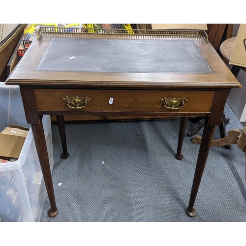 152 - An early 20th century Georgian style mahogany writing desk having a gilt metal gallery top and a sin... 