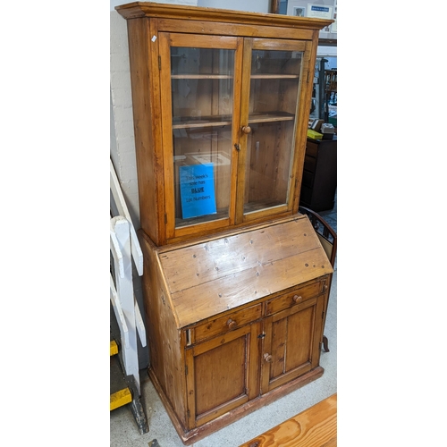 156 - A 19th century pine bureau bookcase having glazed doors above a fall flap with a fitted interior 210... 