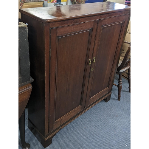 208 - A Georgian mahogany two door cabinet with two loose shelves and on bracket shaped feet 121.5cm h x 1... 