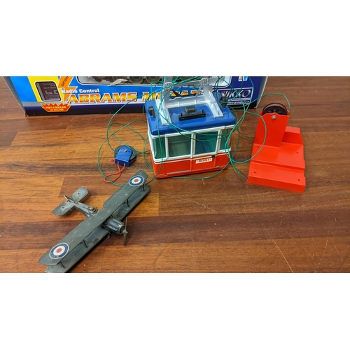 307 - A Lehman skilift tin Rigi cable car, an Abrahams Mi radio controlled tank and a painted wooded bi-pl... 